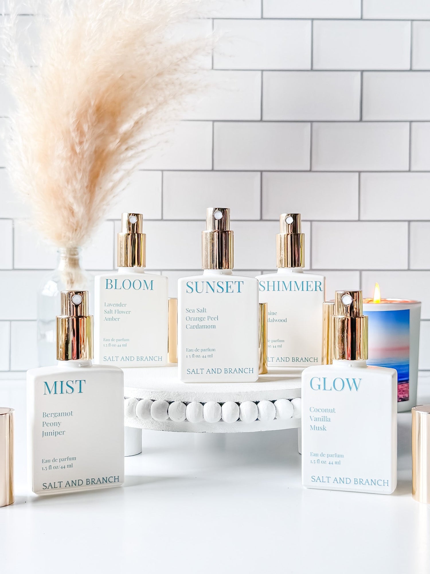 White glass perfume bottle with gold sprayer and teal words Salt and Branch