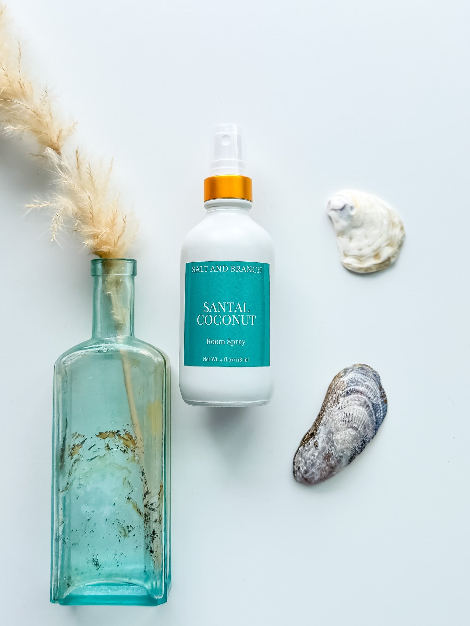 Salt and branch room spray bottles laying in a wooden bowl