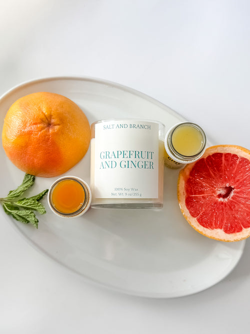 Grapefruit and Ginger Soy Candle on white tray with grapefruit slices Salt and Branch
