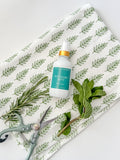 rosemary mint room spray bottle on tea towel with fresh rosemary and mint leaves Salt and Branch