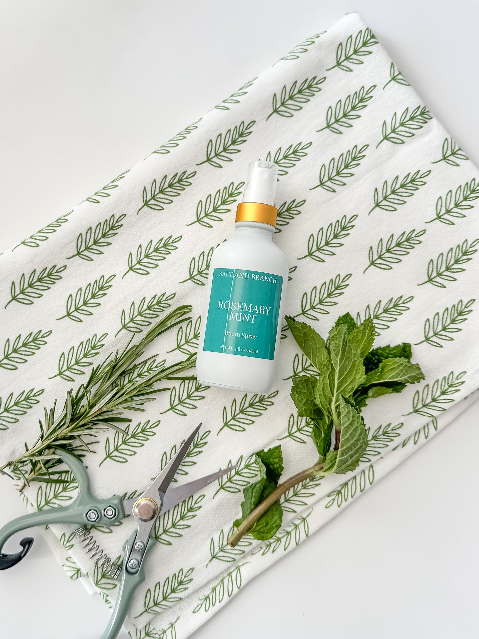 rosemary mint room spray bottle on tea towel with fresh rosemary and mint leaves Salt and Branch